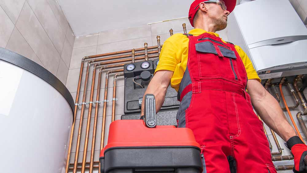 A furnace technician carrying toolbox for maintenance